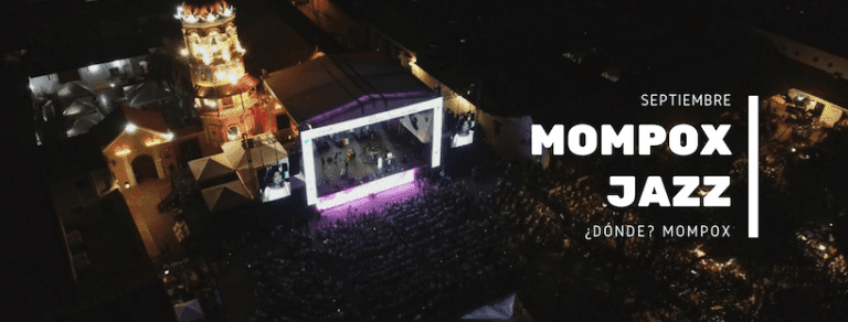 Vista aérea nocturna del escenario del Mompox Jazz Festival con la iglesia colonial y miles de espectadores en la plaza.