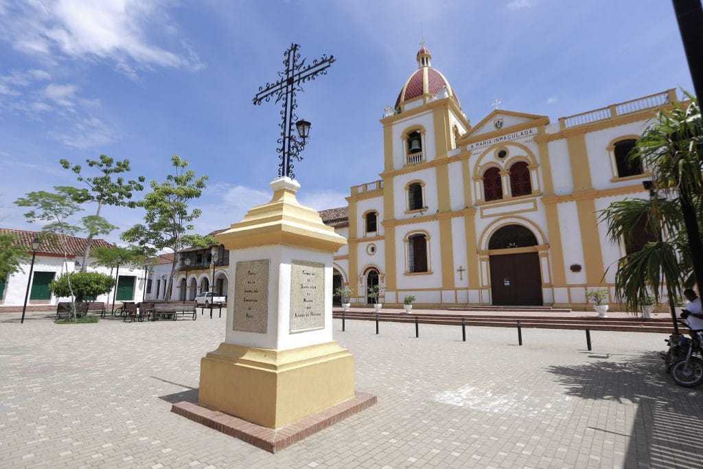 Plaza principal de Mompox con monumento en primer plano y la Iglesia de Santa María la Inmaculada al fondo.